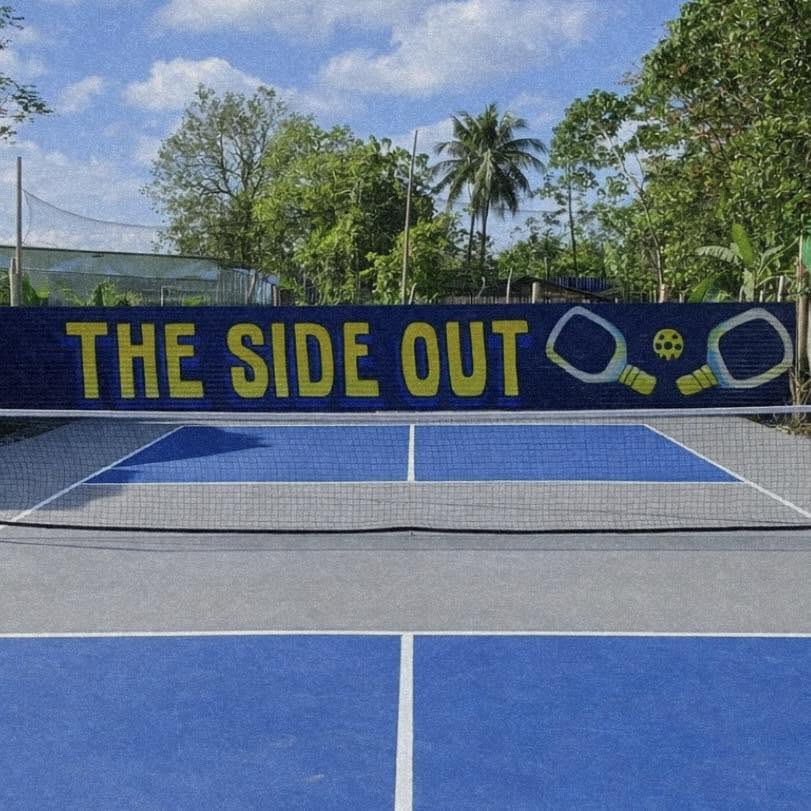 The Side Out outdoor pickleball court in Barangay Banica, Roxas City — blue playing surface, net, and hand-painted fence branding